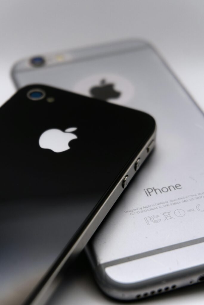 Detailed shot of two smartphones featuring the Apple logo, showcasing modern technology design.